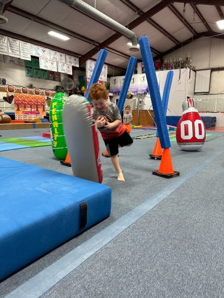 A boy doing football day in the gym